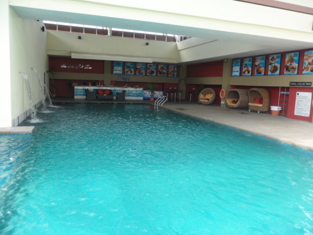 Swimming pool with water feature that can do shoulder massages at Novotel Kota Kinabalu