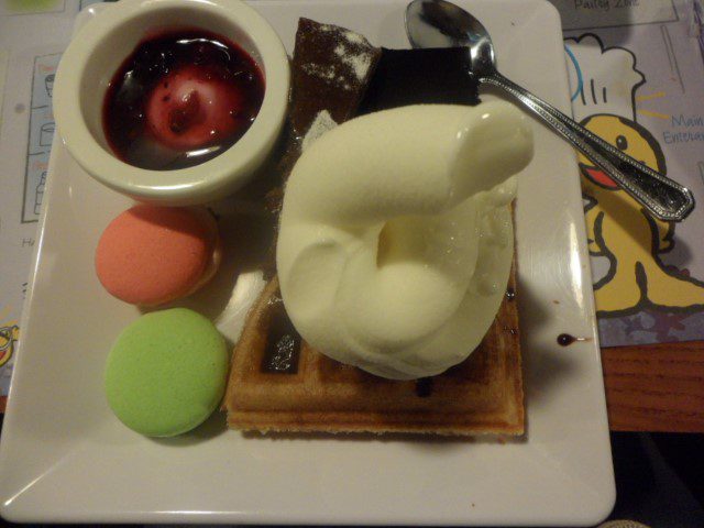 Yummy waffles with soft serve icecream, berry yohgurt, orange chococalate cake, banana chocolate and macarons!