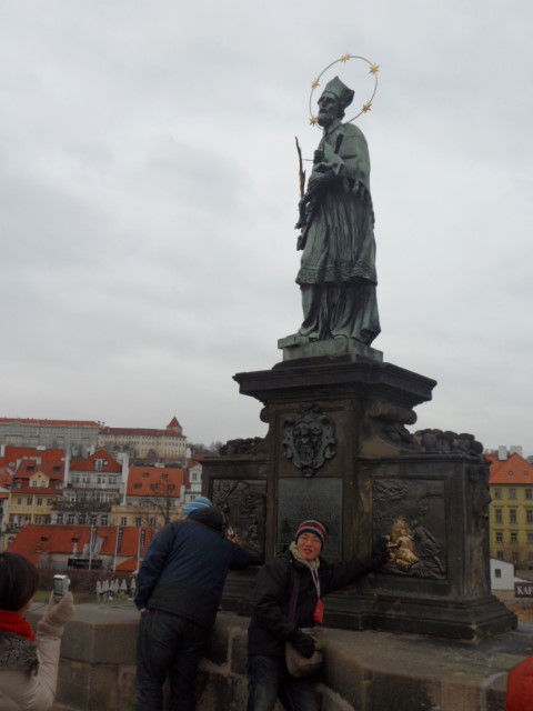 Taking turns to touch statues on Charles Bridge Prague