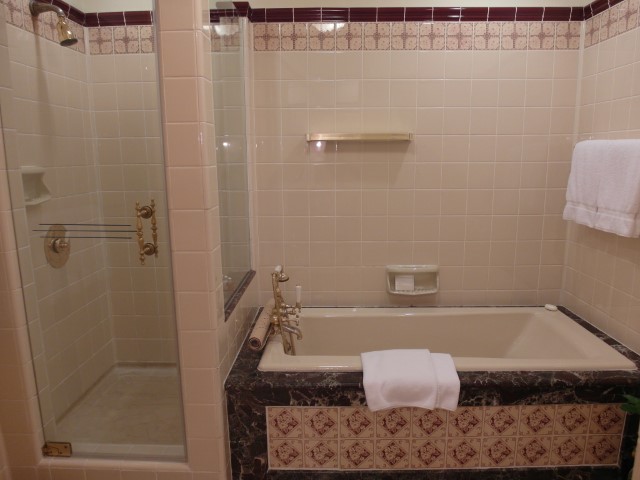 Spacious bathroom with bathtub and separate shower point of Raffles Hotel Suite