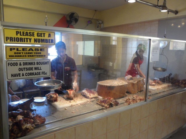 Females chopping up whole pigs at CnT Lechon