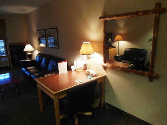 Spacious living room, comfy sofa, balcony and fire place in Suite of Heathman Lodge