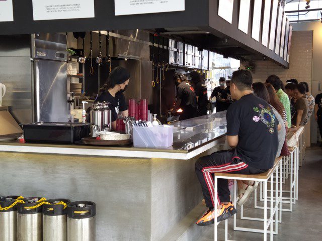 Patrons awaiting at the counter of Menbaka Kyoto Fire Ramen