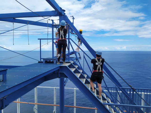 Trying to unlock the carabiners on World Dream Rope Course