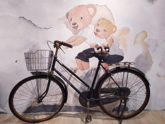 Famous "Little Children on Bicycle" Mural in Penang - 2bearbear sitting on the bicycle @ TeddyVille Museum Batu Ferringhi