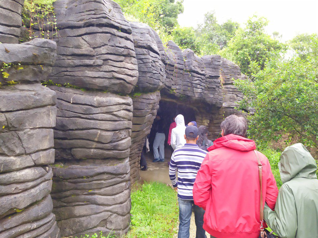 Walking towards the entrance of Waitomo Glowworm Caves - The layered rocks here aren't real...