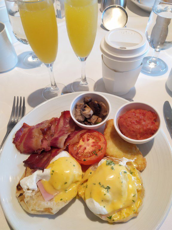 Spectrum of the Seas Main Dining Room Breakfast Eggs Benedict with bacon, mushroom, corned beef, hashbrown (Royal Caribbean Cruise) along with mimosa