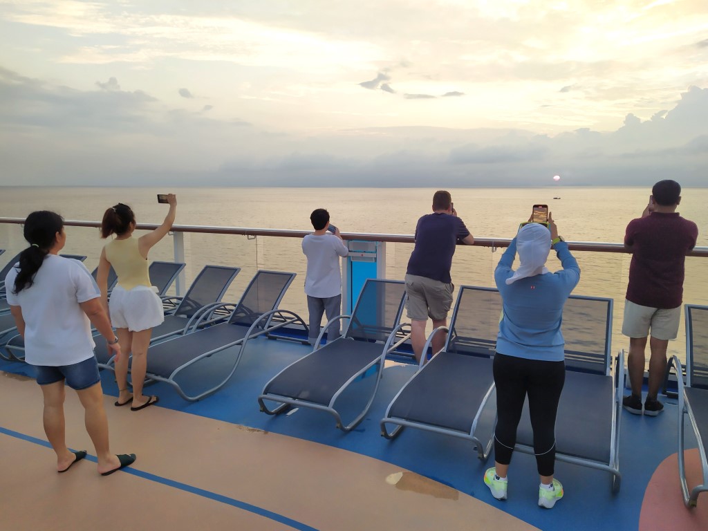 Guests catching morning sunrise from Spectrum of the Seas on last sea day Royal Caribbean Cruise