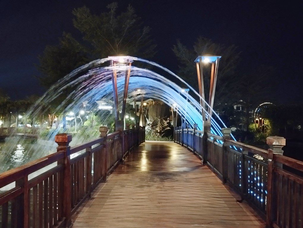 Crossing a bridge with water jet streams passing overhead at Urban Park Vinpearl Grand World Phu Quoc